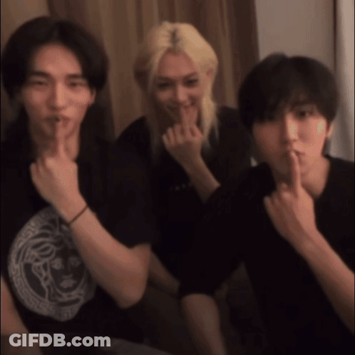 Three Young Men Are Posing For A Picture And One Of Them Is Holding His Finger To His Mouth GIF