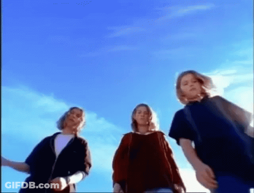 Three Young People Are Standing In Front Of A Blue Sky . GIF