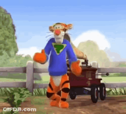 Tigger From Winnie The Pooh Is Standing Next To A Red Wagon And Wearing A Blue Shirt . GIF
