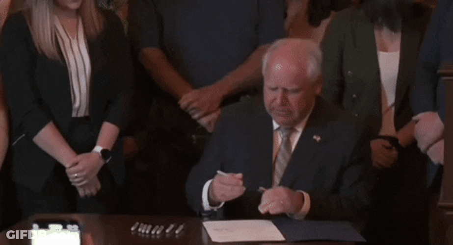 Tim Walz Showing The Signed Law GIF