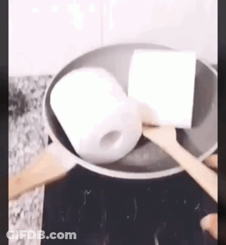 Toilet Paper Being Cooked In Frying Pan With Wooden Spoon GIF