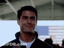 Tom Cruise Is Smiling And Looking At The Camera While Wearing A Jacket . GIF
