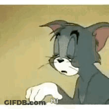Tom From Tom And Jerry Is Sitting Down With His Eyes Closed And A Hand In His Mouth . GIF