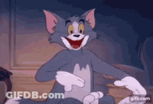 Tom From Tom And Jerry Is Smiling And Pointing At Something . GIF