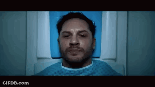 Tom Hardy Is Laying In A Hospital Bed With His Eyes Closed And A Beard . GIF