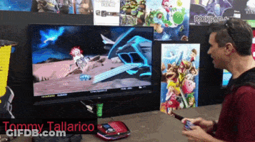 Tommy Tallarico Playing Video Game On Large Screen GIF