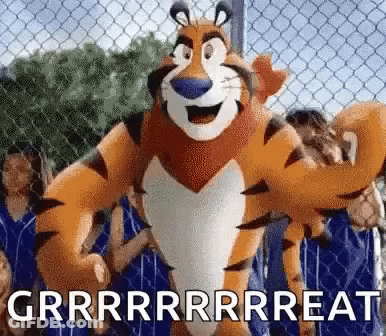 Tony The Tiger Is Standing In Front Of A Chain Link Fence With A Bunch Of People Behind Him . GIF