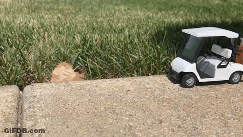 Toy Golf Cart On Sidewalk By Golf Course GIF