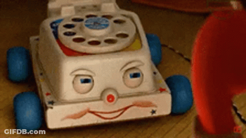 Toy Telephone With Face Next To Red Telephone GIF