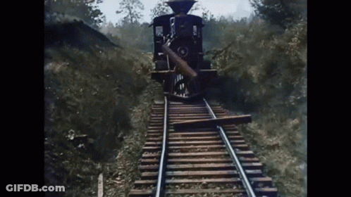 Train Approaching Wood On Tracks GIF