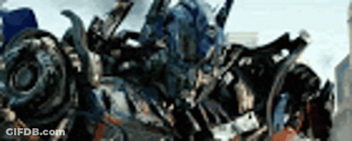 Transformer Standing In Front Of Blurry City GIF