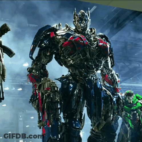 Transformer Standing In Front Of Sign Saying V32 GIF