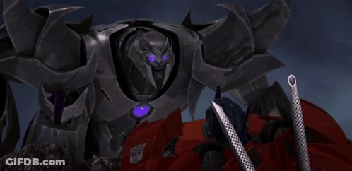 Transformer With Purple Eyes Next To Red Vehicle GIF