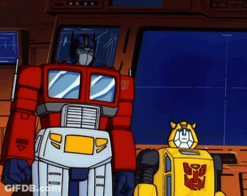 Transformers Optimus Prime And Bumblebee Standing Next To Each Other GIF