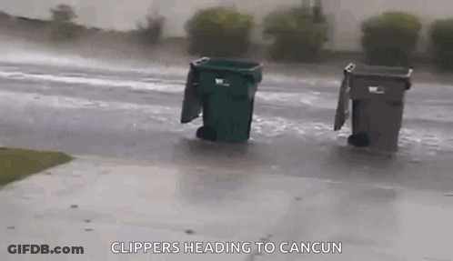 Trash Cans Sitting In Rain On Side Of Road GIF