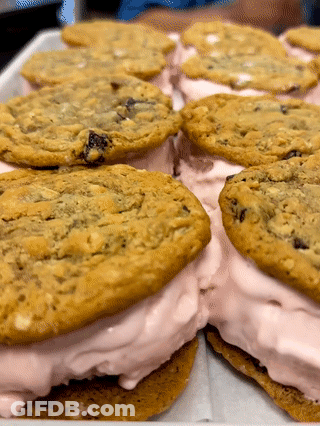 Tray Of Ice Cream Sandwiches With Chocolate Chip Cookies And Pink Frosting GIF