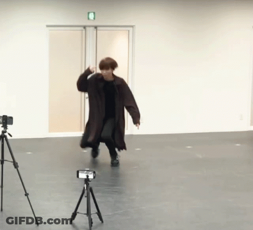 Trench Coat Man Dancing Next To Camera Tripod GIF