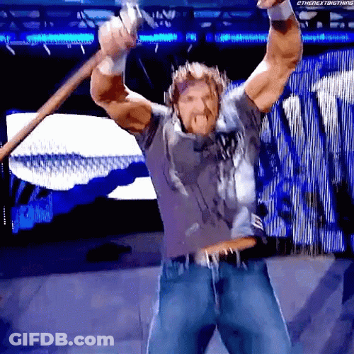 Triple H Flexing Muscle While Holding Sledgehammer GIF