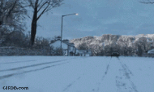 Truck Driving Down Snowy Street GIF