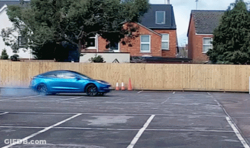 Truck Driving Down Street With Car Behind GIF