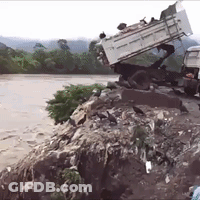 Truck On Pile Of Rocks Near River GIF