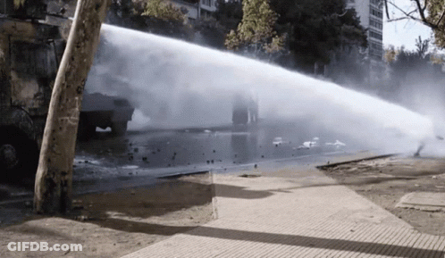 Truck Spraying Water On Sidewalk With Smoke GIF