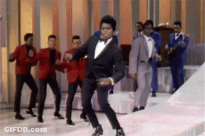 Tuxedo Man Dancing With Other Men On Stage GIF