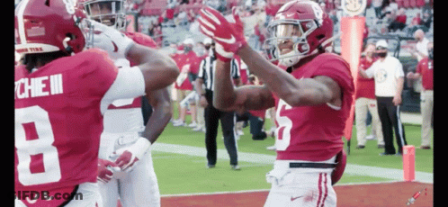 Two Alabama Football Players Are High Fiving Each Other GIF