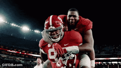 Two Alabama Football Players Hugging On Field GIF