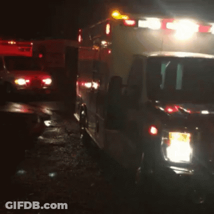 Two Ambulances Parked Next To Each Other In Dark GIF