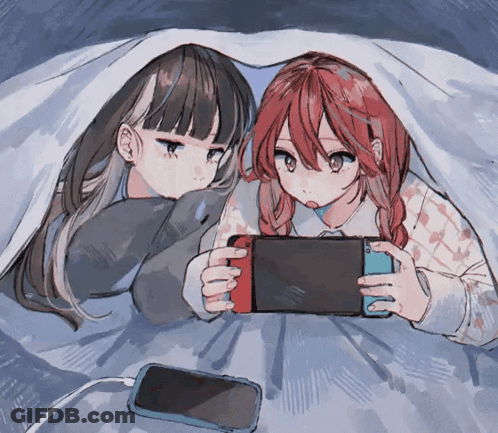 Two Anime Girls Laying Under A Blanket Playing A Game GIF