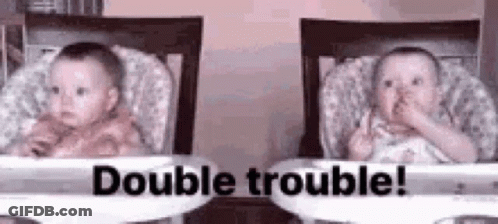 Two Babies Are Sitting In High Chairs And One Of Them Is Making A Funny Face . GIF