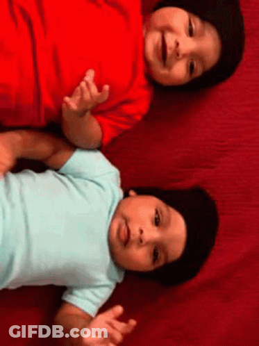 Two Babies Laying On Red Blanket GIF
