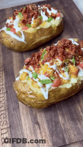 Two Baked Potatoes Are Sitting On A Wooden Cutting Board That Says Let 'S Smoke Shisha On It GIF