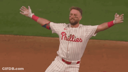 Two Baseball Players Are Hugging Each Other And One Of Them Has The Number 12 On His Jersey GIF