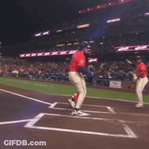 Two Baseball Players Are Jumping In The Air On A Field With A Sign That Says Get Water In The Background GIF