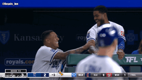 Two Baseball Players Are Shaking Hands In A Dugout With A Kansas City Ad Behind Them GIF