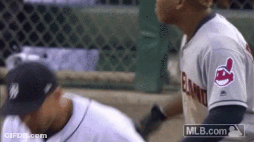 Two Baseball Players Are Standing Next To Each Other On The Field . One Of The Players Is Wearing An Indians Jersey . GIF