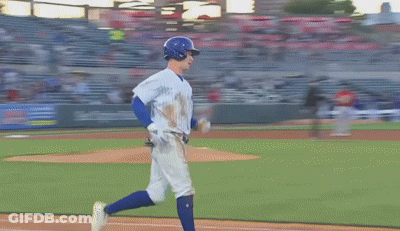 Two Baseball Players Are Standing On A Field With Advertisements On The Wall GIF