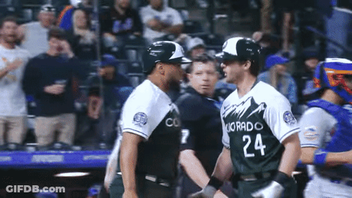 Two Baseball Players From The Colorado Rockies Are Shaking Hands GIF