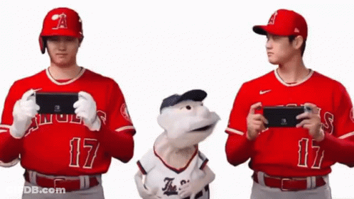 Two Baseball Players Holding Nintendo Switch Next To Stuffed Animal GIF