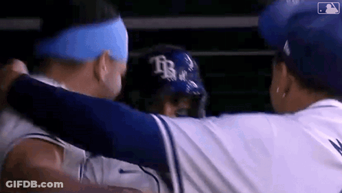 Two Baseball Players Hugging In Dugout GIF