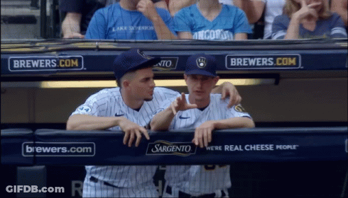 Two Baseball Players In A Dugout With Brewers.com Advertisements Behind Them GIF