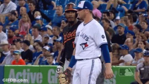 Two Baseball Players In Stadium One In Blue Jays Jersey GIF