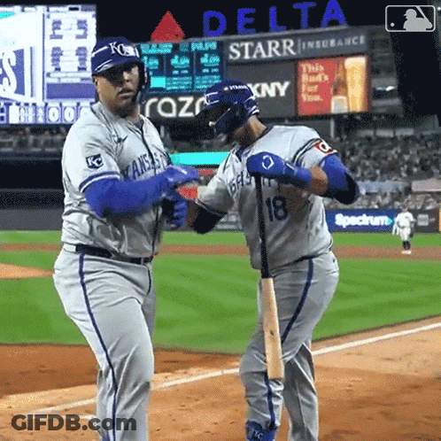 Two Baseball Players On A Field With A Delta Advertisement In The Background GIF