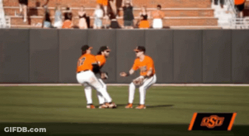 Two Baseball Players On A Field With A Sign That Says Ost In The Background GIF