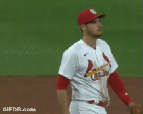 Two Baseball Players , One Wearing A Red Hat And The Other Wearing A White Jersey , Are Shaking Hands On The Field . GIF