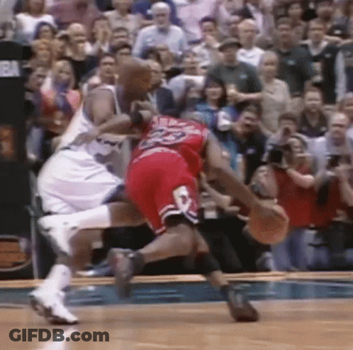 Two Basketball Players Are Fighting For The Ball On A Court . GIF