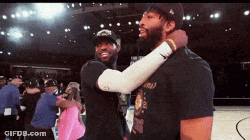 Two Basketball Players Are Hugging Each Other On A Basketball Court GIF