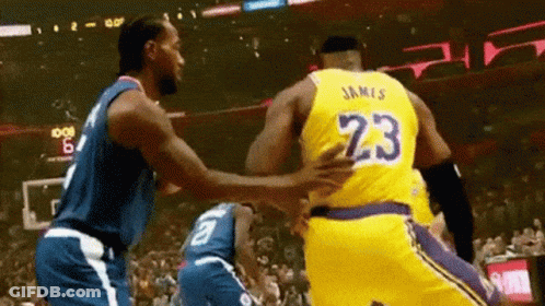 Two Basketball Players Are Hugging Each Other On A Court . GIF